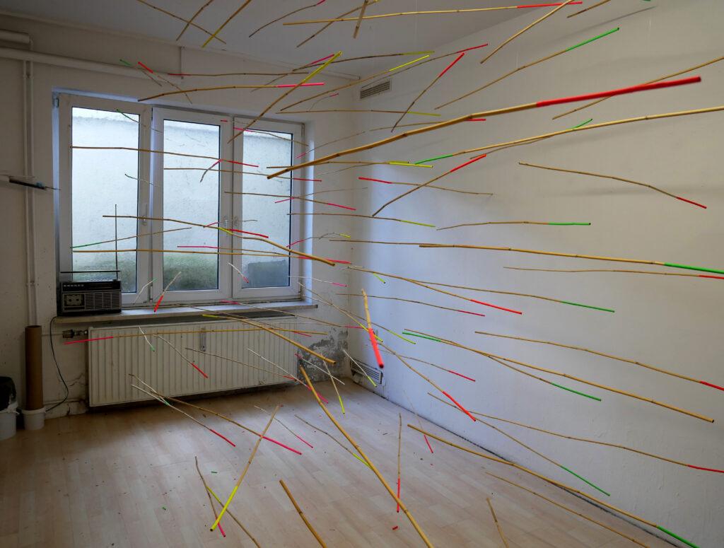 Nausikaa Hacker: Wo lang? 2022 Installation mit Schilfstäben, Neonfarben und Magneten, ca. 410 cm x 270 cm